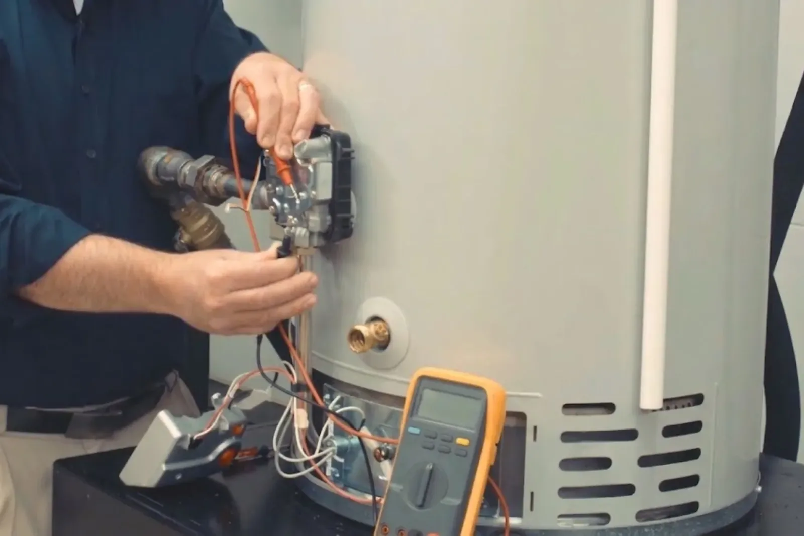 Technician testing a gas water heater with a multimeter