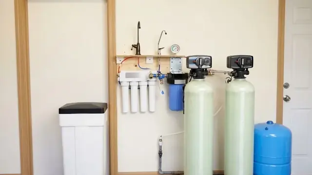 Water softener tanks and a reverse osmosis filter mounted on a garage wall