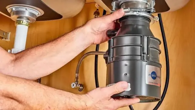 Hands servicing a garbage disposal mounted under a kitchen sink